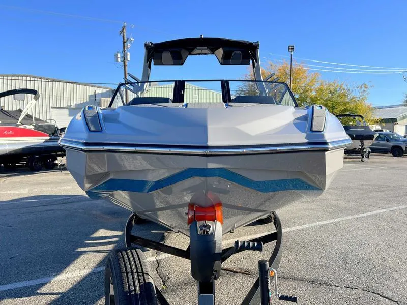 Slide: The Image of 2024 Supra SL boat on trailer, parked outdoors, clear sky background. - 16