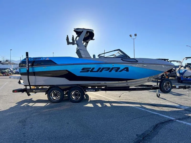 Slide: The Image of 2024 Supra SL boat on trailer in parking lot, side view. - 25