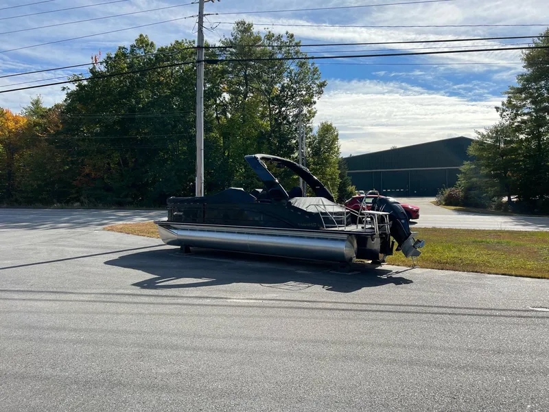 Slide: The Image of 2023 Harris Solstice DC 250 pontoon boat parked on a sunny day. - 2