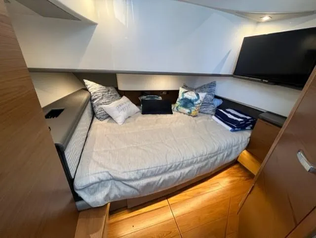 Slide: The Image of 2021 Tiara Yachts 38 LS cabin with bed, pillows, and TV. - 10