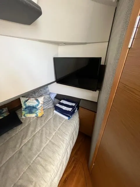 Slide: The Image of 2021 Tiara Yachts 38 LS cabin with bed, TV, and wooden interior. - 11