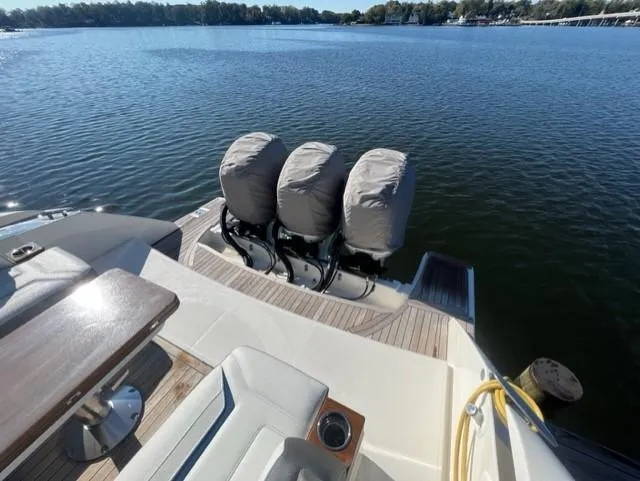 Slide: The Image of 2021 Tiara Yachts 38 LS with triple outboard engines on a serene lake. - 15