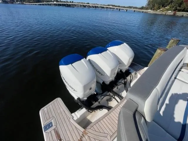 Slide: The Image of 2021 Tiara Yachts 38 LS with triple outboard engines docked on calm water. - 16