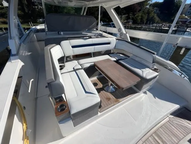 Slide: The Image of 2021 Tiara Yachts 38 LS boat with spacious seating and wooden table. - 2