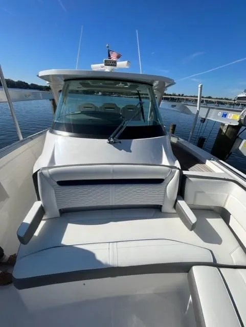 Slide: The Image of 2021 Tiara Yachts 38 LS boat docked, featuring spacious seating and sleek design. - 8