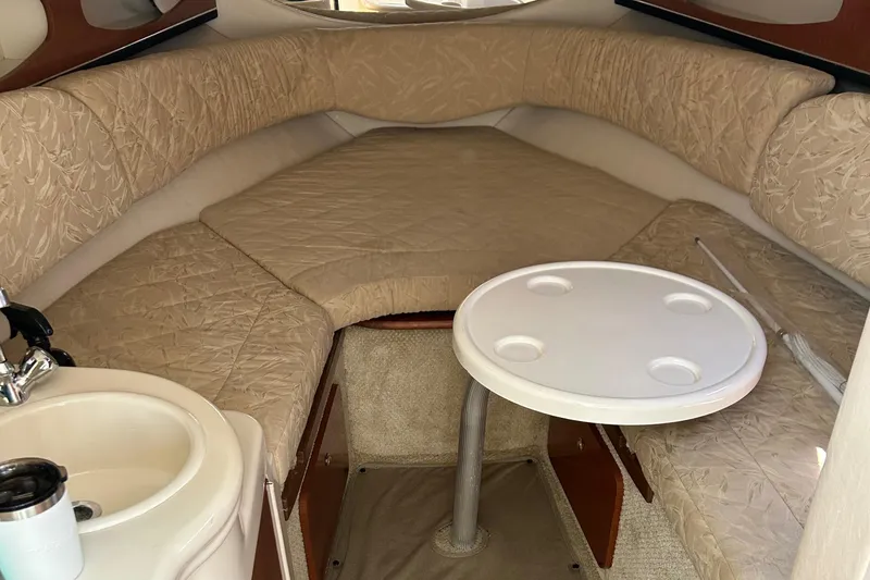 Slide: The Image of Interior cabin of a 2004 Sea Ray 260 DA boat with beige seating and a small table. - 10