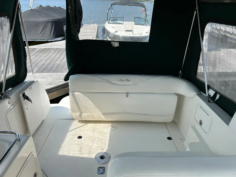 Slide: The Image of Interior of a 2004 Sea Ray 260 DA boat with white seating and dock view. - 3