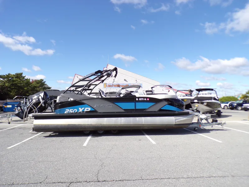 Slide: The Image of 2018 Godfrey Aqua Padio 250 XP pontoon boat in a parking lot under a clear sky. - 1