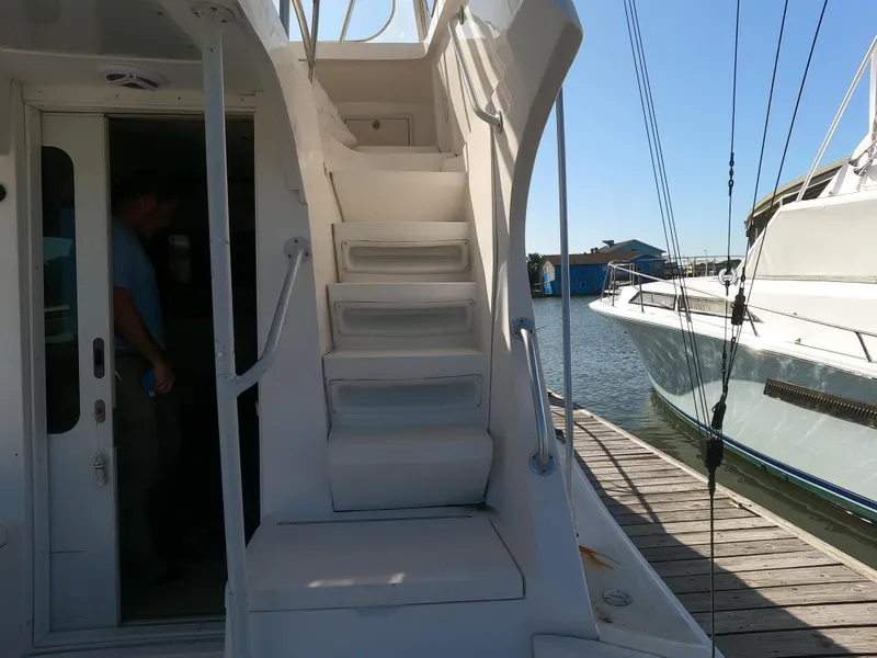 Slide: The Image of 2002 Luhrs 34 Convertible yacht docked, showing exterior stairs and partial interior view. - 12