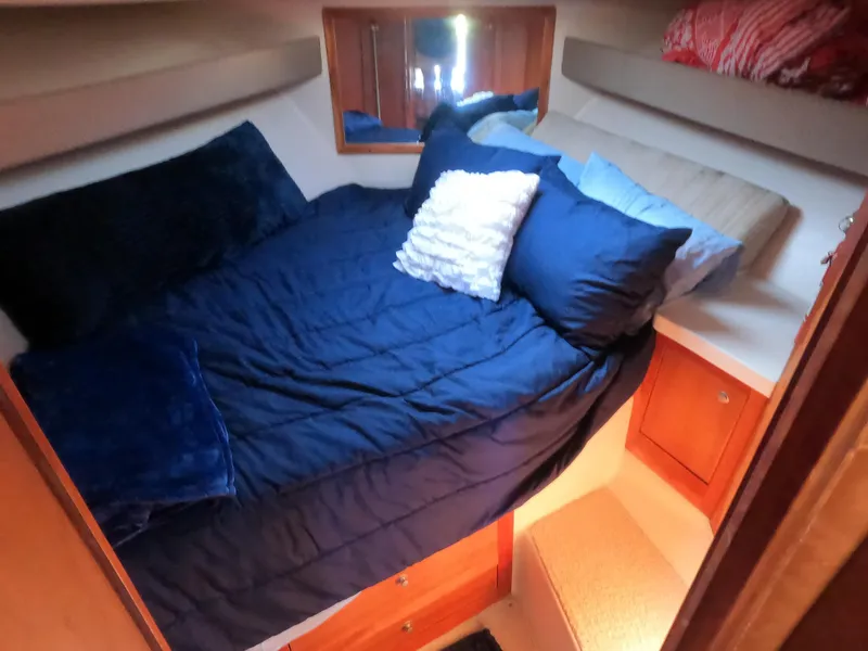 Slide: The Image of 2002 Luhrs 34 Convertible cabin with cozy bed and pillows. - 21