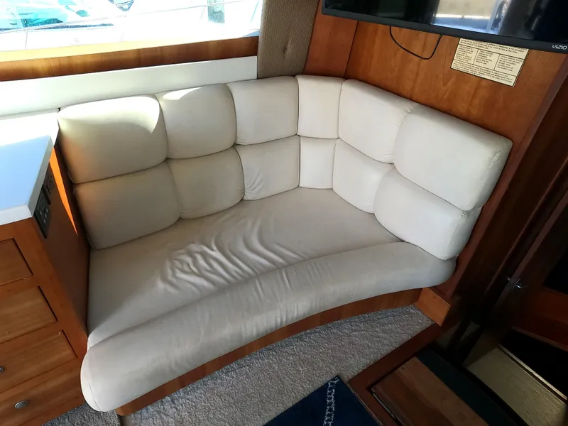 Slide: The Image of 2002 Luhrs 34 Convertible boat interior with beige cushioned seating. - 25