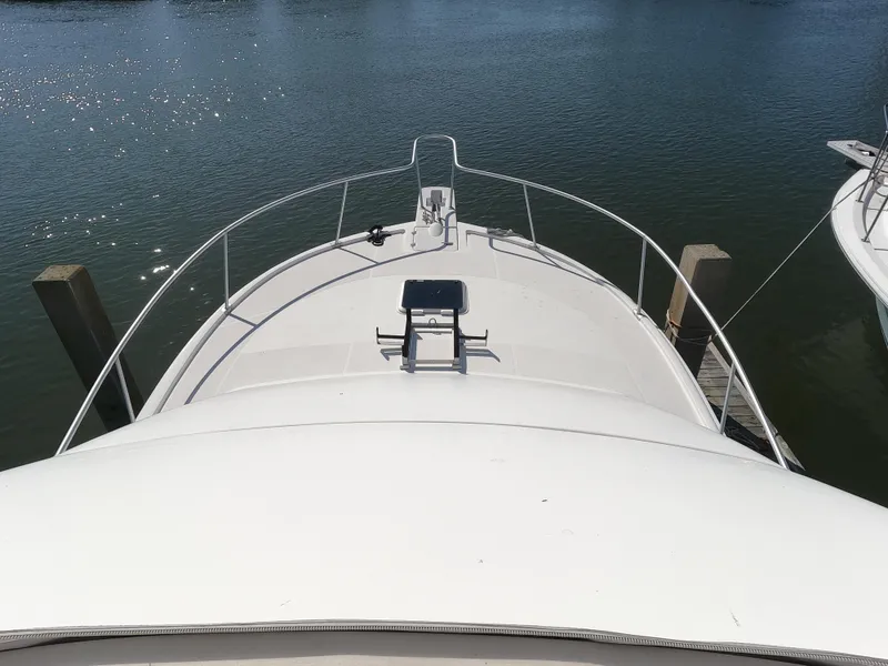Slide: The Image of Bow view of 2002 Luhrs 34 Convertible boat docked on calm water. - 3