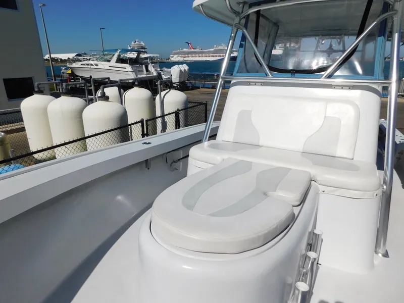 Slide: The Image of 2004 Mirage 32 boat with cushioned seating at a marina. - 19