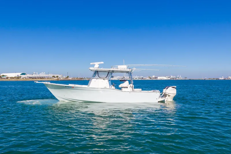 Slide: The Image of 2004 Mirage 32 boat cruising on clear blue water. - 2