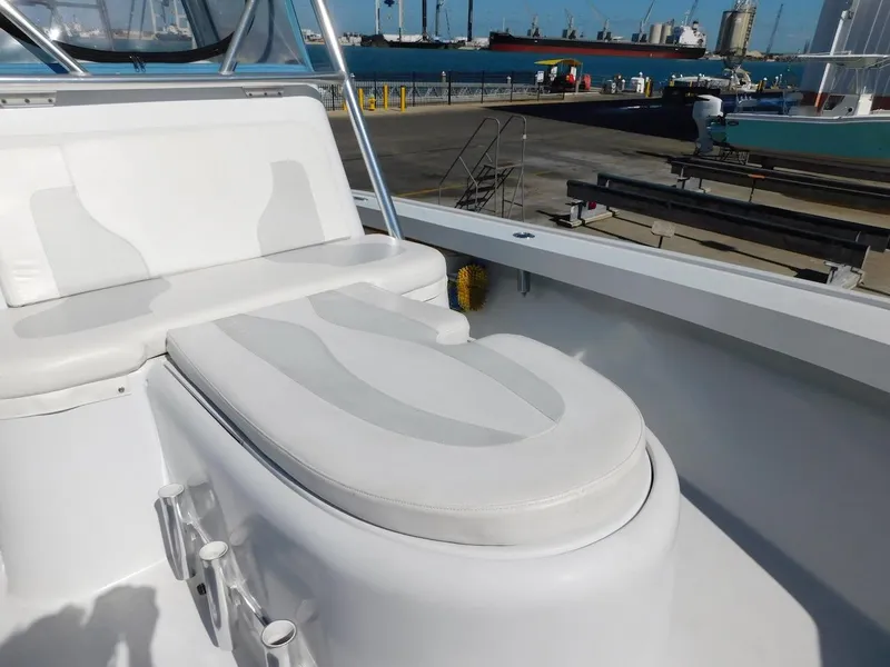 Slide: The Image of 2004 Mirage 32 boat with white cushioned seating at a dock. - 20