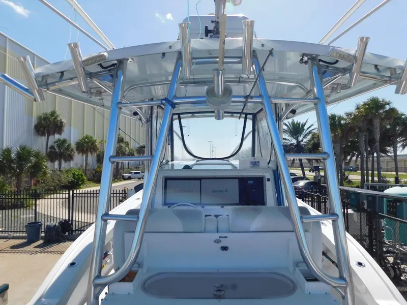 Slide: The Image of 2004 Mirage 32 boat with T-top and rod holders in marina. - 25