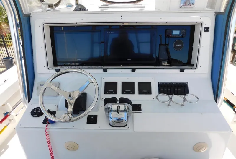 Slide: The Image of 2004 Mirage 32 boat dashboard with steering wheel, controls, and navigation screens. - 27
