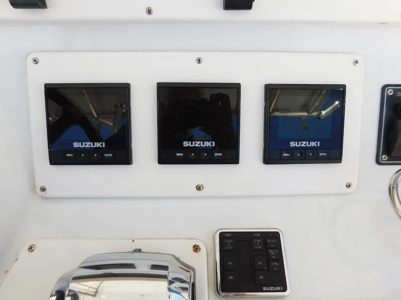Slide: The Image of 2004 Mirage 32 boat dashboard with Suzuki engine displays and controls - 29