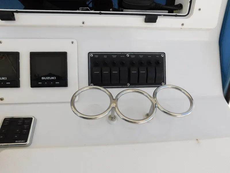 Slide: The Image of Control panel of a 2004 Mirage 32 boat with Suzuki displays and cup holders. - 31