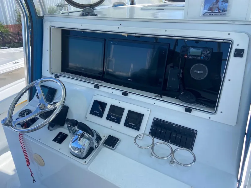 Slide: The Image of Mirage 32 boat dashboard, 2004 model, featuring steering wheel, controls, and navigation screens. - 33