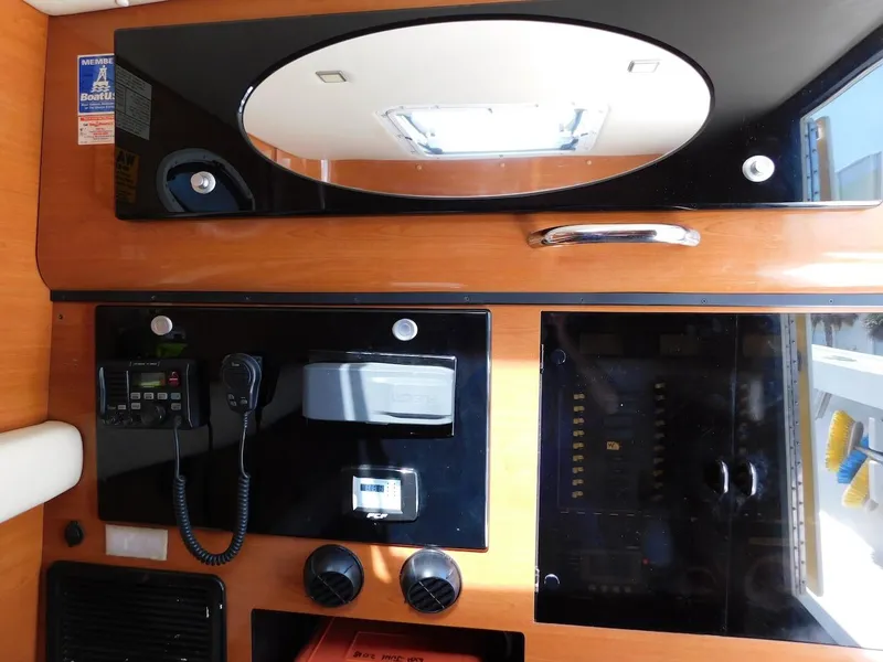 Slide: The Image of Control panel inside a 2004 Mirage 32 boat with communication equipment and storage compartments. - 38