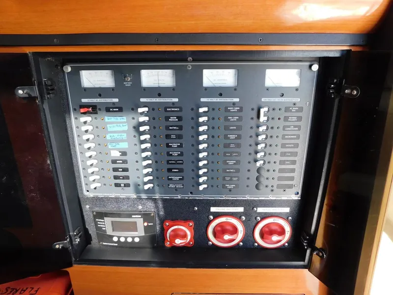 Slide: The Image of Electrical control panel of a 2004 Mirage 32 boat with switches and gauges. - 39