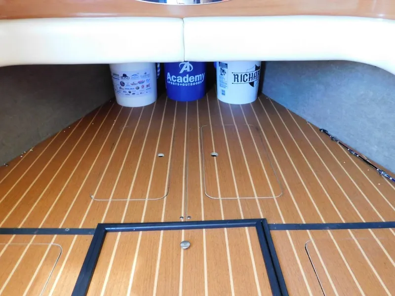 Slide: The Image of 2004 Mirage 32 boat interior with wooden flooring and storage buckets. - 43