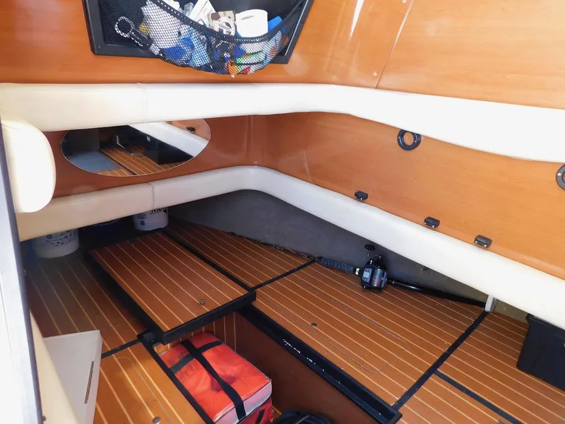 Slide: The Image of Interior cabin of a 2004 Mirage 32 boat with wooden flooring and storage compartments. - 44