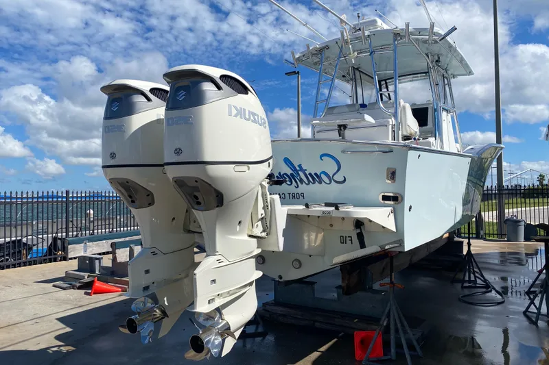 Slide: The Image of 2004 Mirage 32 boat with twin Suzuki outboard engines on a dock. - 8