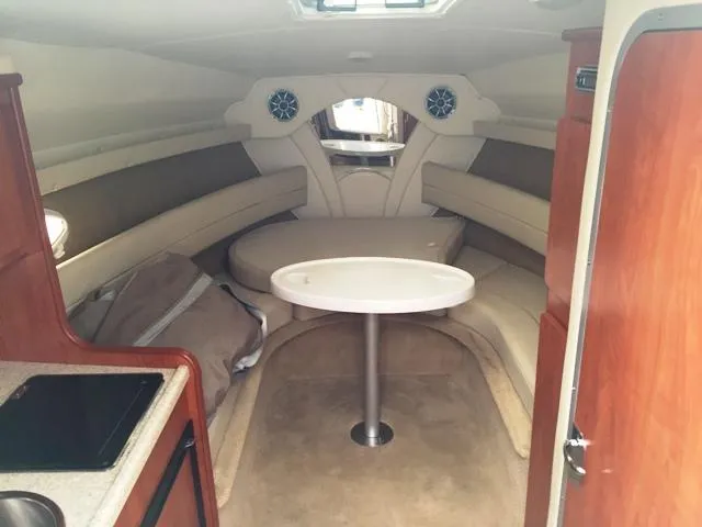 Slide: The Image of 2007 Rinker 270 Express Cruiser cabin interior with seating and table. - 11