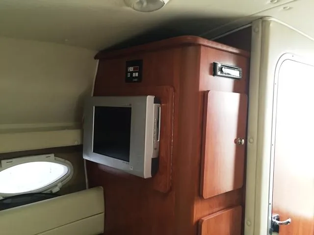 Slide: The Image of Interior of 2007 Rinker 270 Express Cruiser with TV and wooden cabinetry. - 12