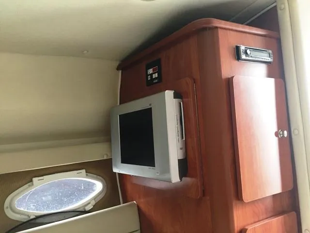Slide: The Image of Interior cabin of 2007 Rinker 270 Express Cruiser with TV and wooden cabinetry. - 13