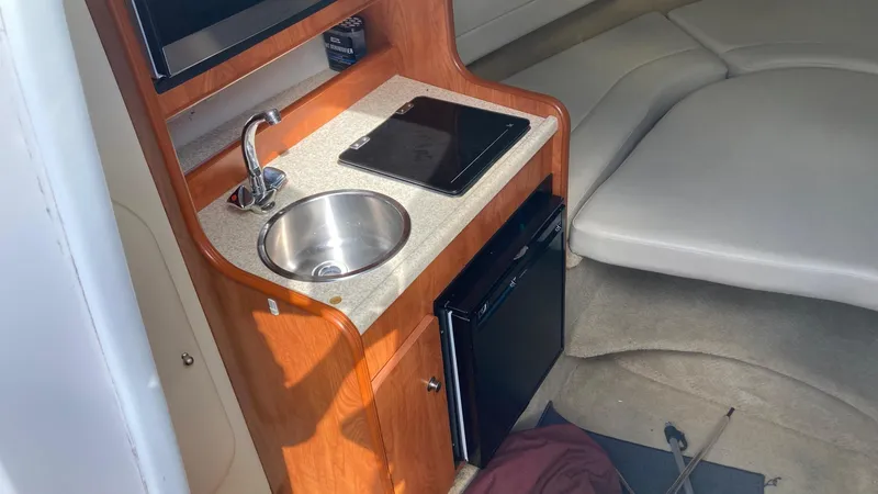 Slide: The Image of 2007 Rinker 270 Express Cruiser interior with kitchenette and seating area. - 15