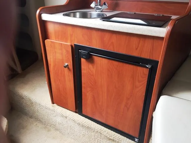 Slide: The Image of 2007 Rinker 270 Express Cruiser kitchenette with sink and mini-fridge. - 17