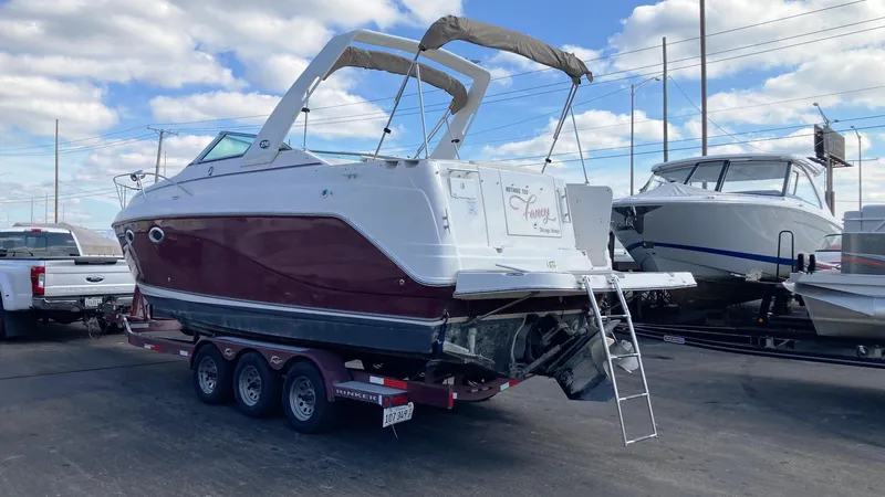 Slide: The Image of 2007 Rinker 270 Express Cruiser on a trailer in a marina. - 2