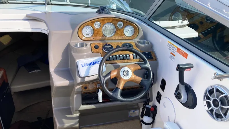 Slide: The Image of 2007 Rinker 270 Express Cruiser helm with woodgrain dashboard and steering wheel. - 7