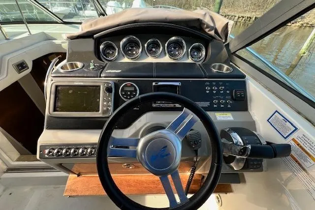 Slide: The Image of 2014 Sea Ray Sundancer 350 helm with steering wheel, gauges, and navigation controls. - 32