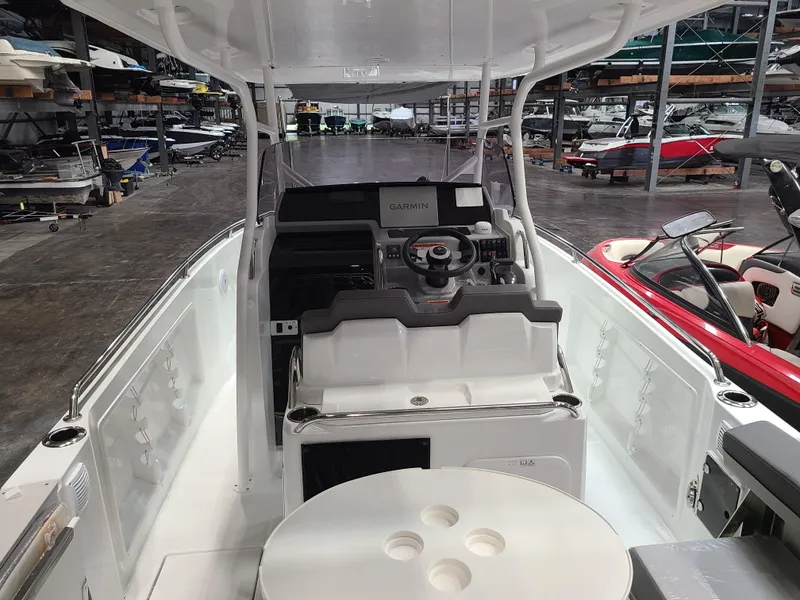 Slide: The Image of 2024 Jeanneau Leader 7.5 WA boat interior with helm and seating in a storage facility. - 5