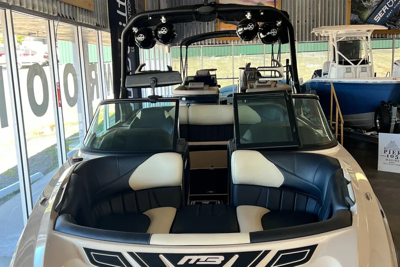 Slide: The Image of 2024 MB F22 Tomcat boat interior with black and white seating in showroom. - 12