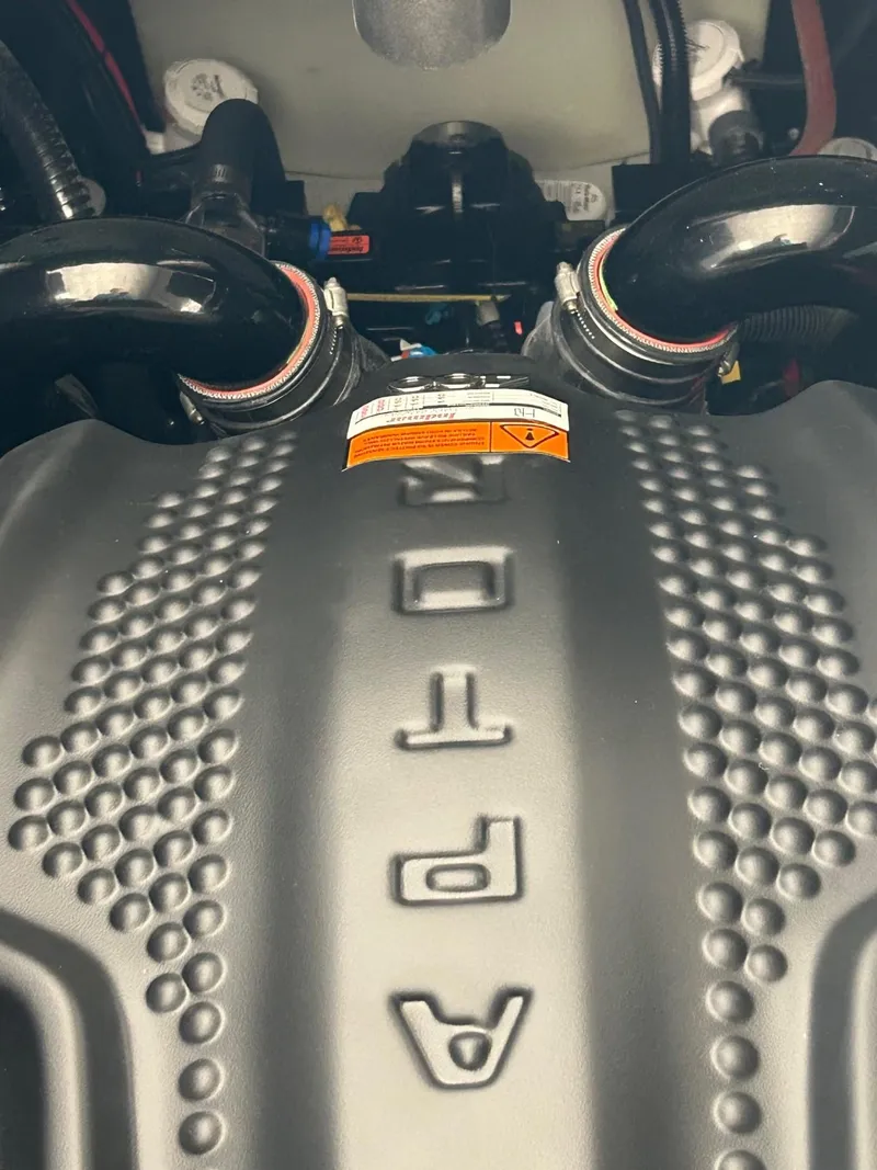 Slide: The Image of Close-up of 2024 MB F22 Tomcat engine cover with textured design and visible hoses. - 2