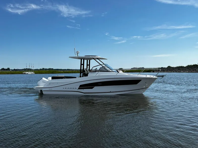Slide: The Image of 2025 Jeanneau Leader 9.0 WA boat cruising on calm water under clear blue sky. - 19