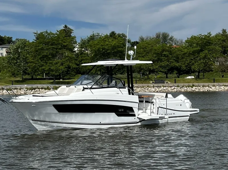 Slide: The Image of 2025 Jeanneau Leader 9.0 WA boat on a calm river with trees in the background. - 2