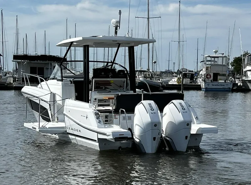 Slide: The Image of 2025 Jeanneau Leader 9.0 WA boat with twin engines docked in a marina. - 25
