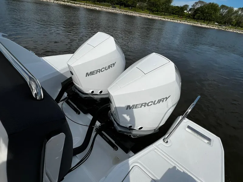 Slide: The Image of 2025 Jeanneau Leader 9.0 WA with twin Mercury outboard engines on a calm lake. - 30