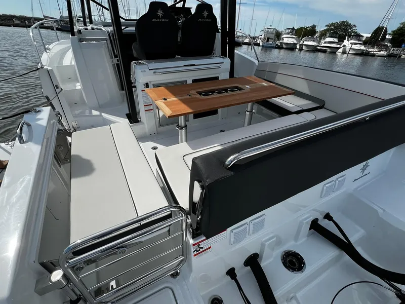 Slide: The Image of 2025 Jeanneau Leader 9.0 WA boat interior with seating and wooden table. - 34