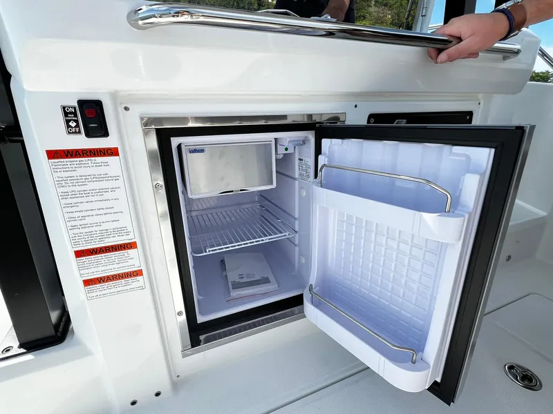 Slide: The Image of 2025 Jeanneau Leader 9.0 WA boat with open mini fridge in cockpit area. - 37