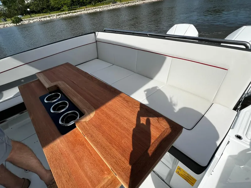 Slide: The Image of 2025 Jeanneau Leader 9.0 WA boat interior with wooden table and cushioned seating. - 40