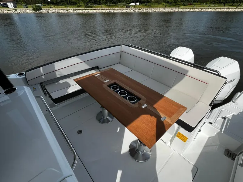 Slide: The Image of 2025 Jeanneau Leader 9.0 WA boat with elegant seating and wooden table on deck. - 41