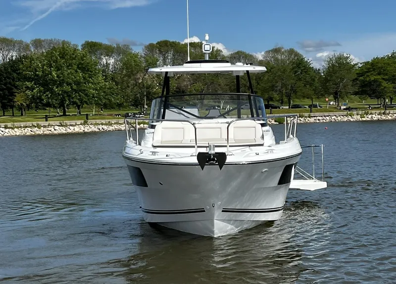 Slide: The Image of 2025 Jeanneau Leader 9.0 WA boat on a calm lake with trees in the background. - 6