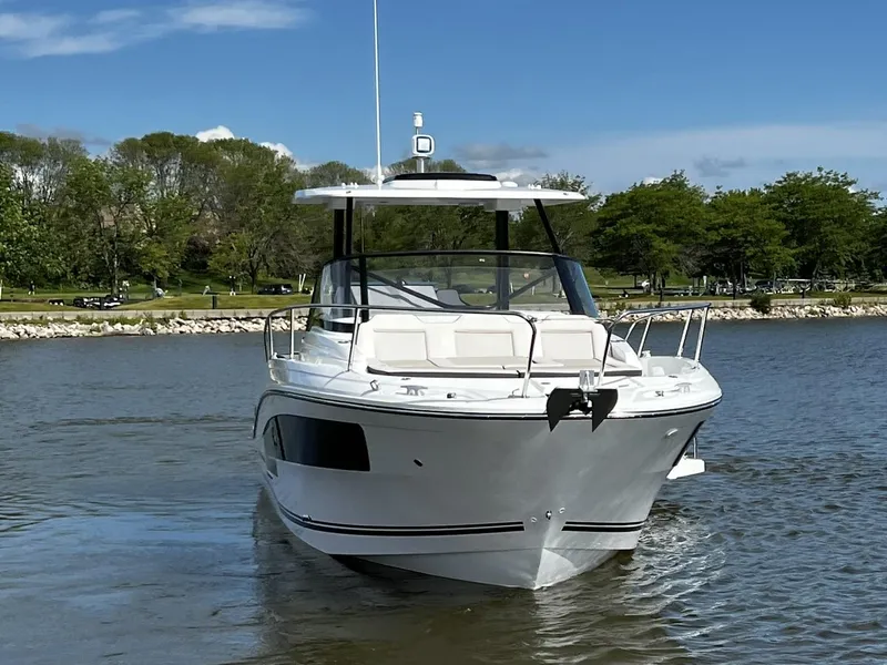 Slide: The Image of 2025 Jeanneau Leader 9.0 WA boat on calm water, surrounded by trees. - 8